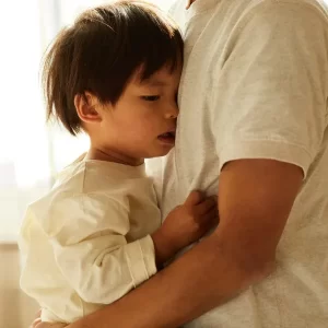 不安な母親が子どもを抱きしめ、背中をさすって安心感を与えている様子