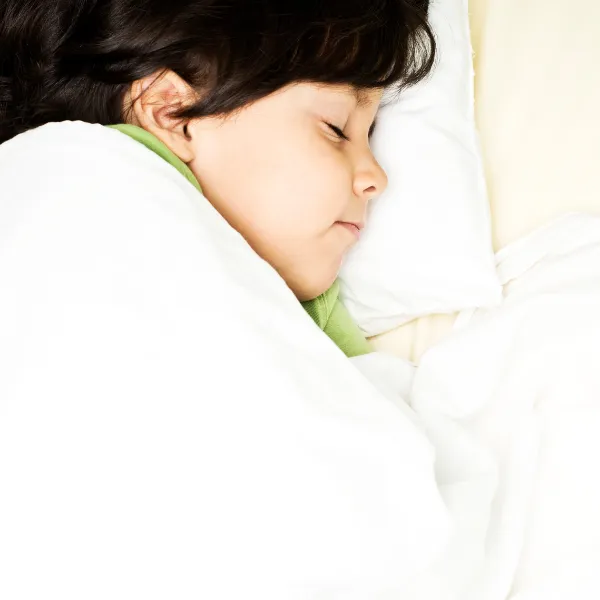 安心した表情で眠る子どもの顔のアップ。情報疲れや自律神経のサインとなるまぶたの動きを観察するイメージ